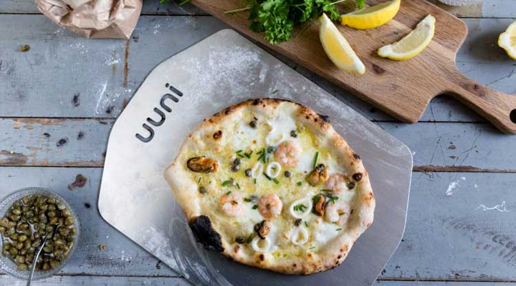 Bring the taste of wood-fired pizza, meat, and fish to your own backyard with the Uuni wood-fired pizza oven.